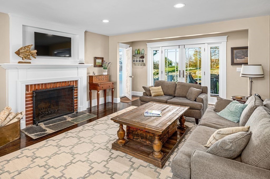 3 Cricket Circle Scituate, MA 02066 - Photo 14 of 42 a living room with furniture a flat screen tv and a fireplace