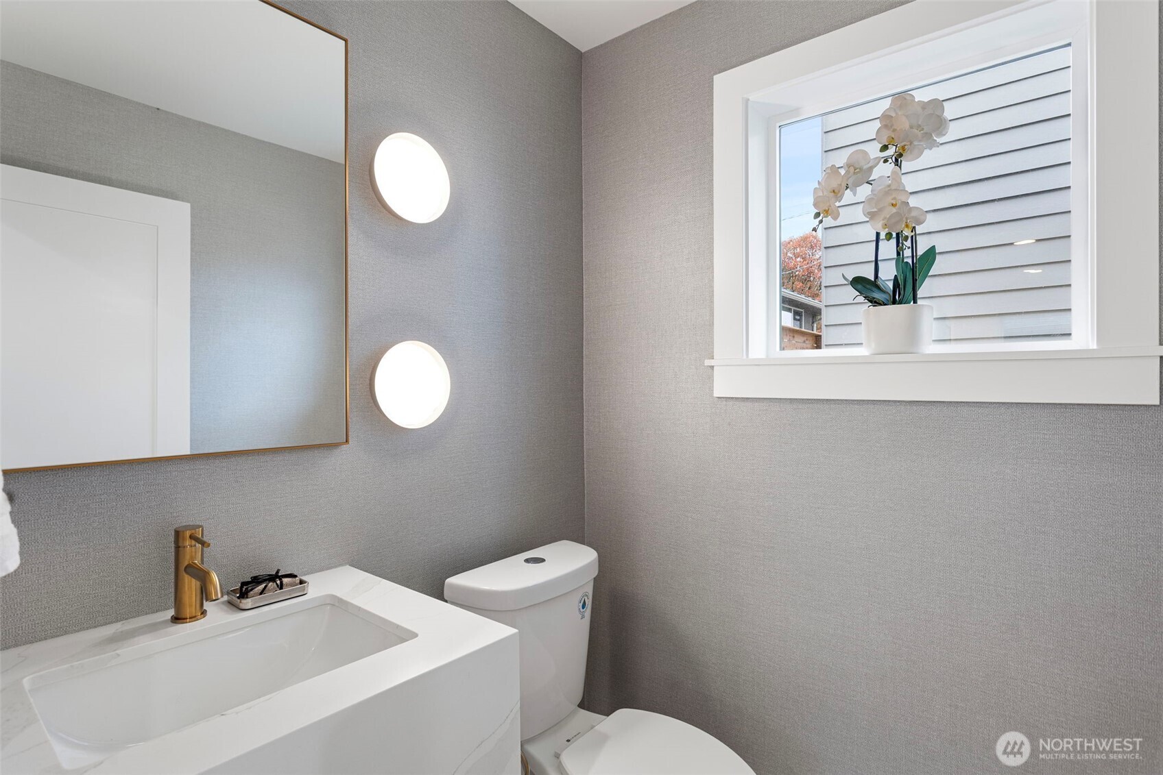 8003 25th Avenue Northwest Seattle, WA 98117 - Photo 15 of 25 a bathroom with a toilet a sink and a mirror
