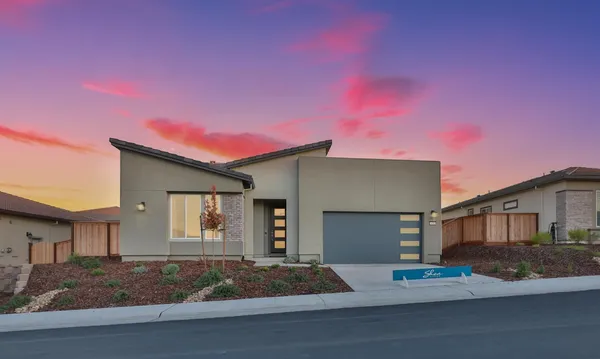 a view of a house with a yard and large tree