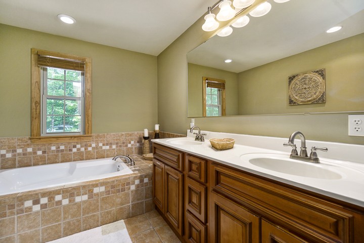 405 Rocky Top Road Sparta, TN 38583 - Photo 22 of 41 a bathroom with a sink a large mirror and a bathtub