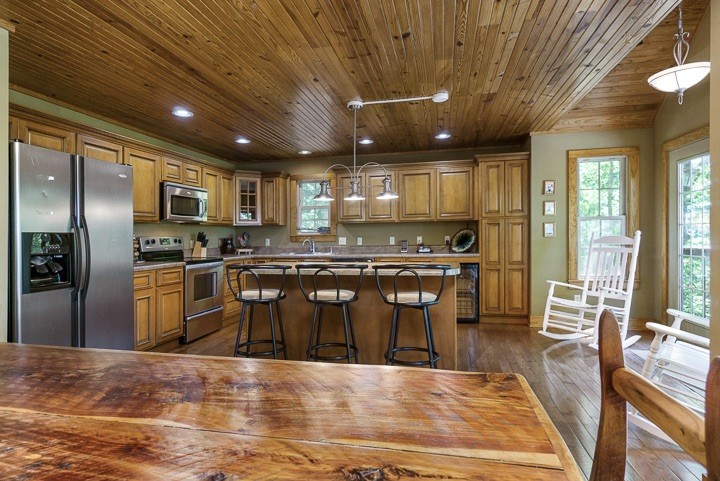 405 Rocky Top Road Sparta, TN 38583 - Photo 10 of 41 a kitchen with stainless steel appliances kitchen island granite countertop a refrigerator a stove a sink a dining table and chairs with wooden floor