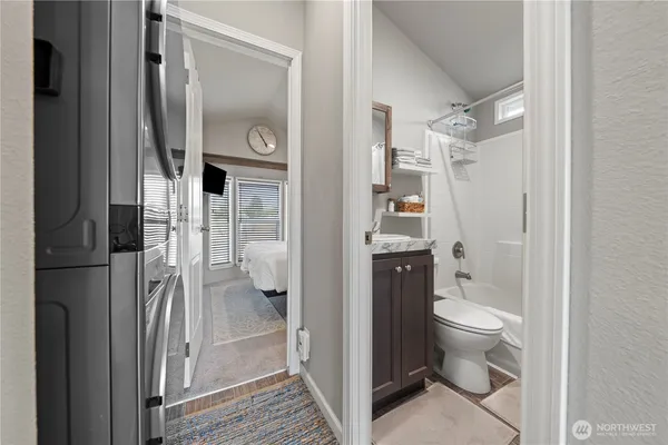 a bedroom with a bed a mirror on dresser and a window