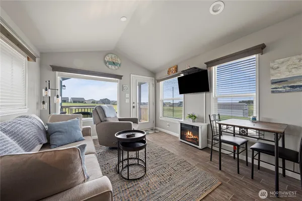 a living room with furniture a flat screen tv and a large window