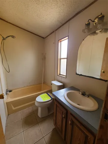 a bathroom with a granite countertop sink a toilet and bathtub