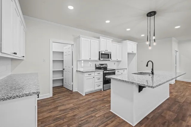 a open kitchen with kitchen island a sink stainless steel appliances and cabinets