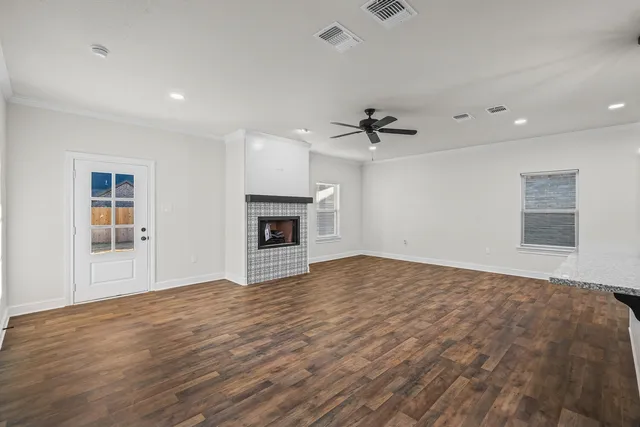 a view of empty room with wooden floor and fireplace
