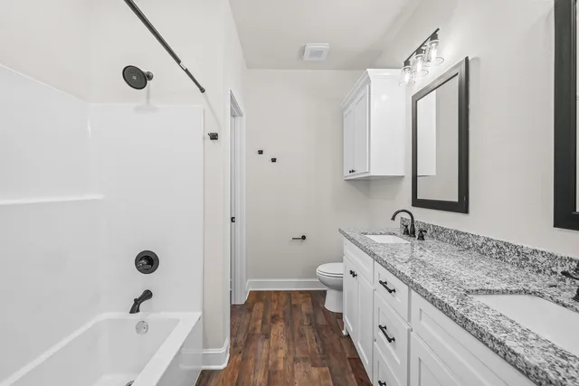 a bathroom with a granite countertop sink mirror and a bathtub