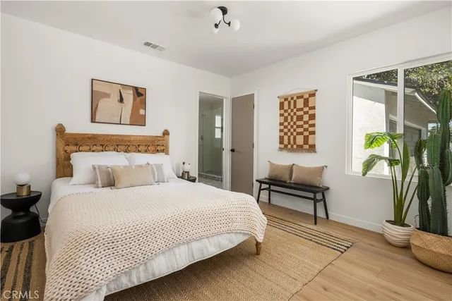 a bedroom with a bed and a potted plant