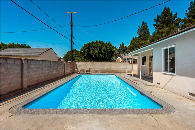 a view of backyard with swimming pool and outdoor seating
