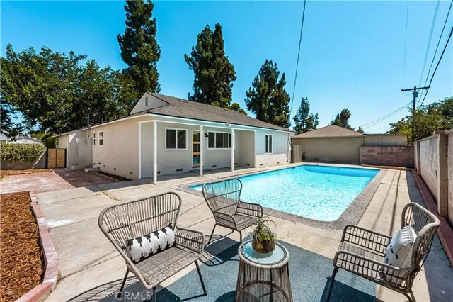 a view of a patio with table and chairs with wooden floor and fence