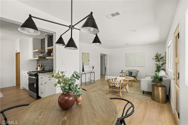 a living room with furniture a chandelier and a wooden floor