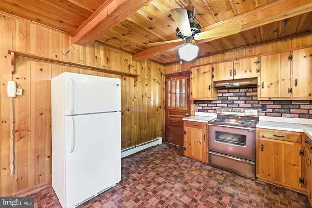 an empty room with wooden floor closet and windows