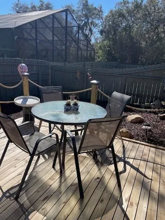 a roof deck with table and chairs and potted plants