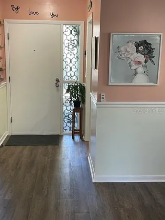 a view of a hallway with wooden floor and a window