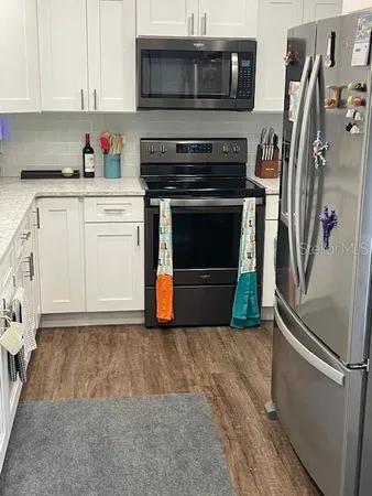 a kitchen with stainless steel appliances a stove a microwave and a refrigerator