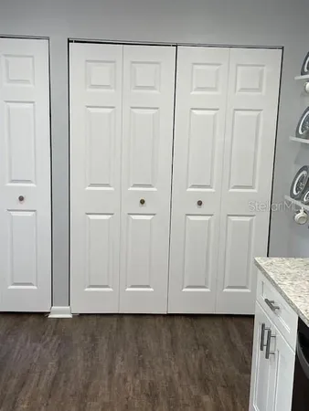 a kitchen with stainless steel appliances cabinets and wooden floor