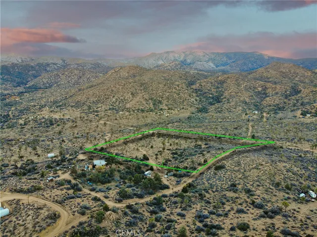 a view of a field with mountains in the background