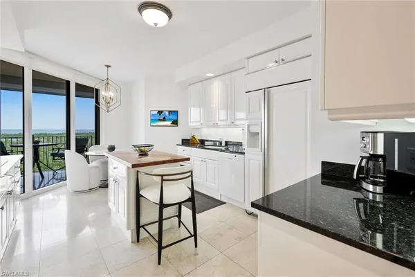a kitchen with a sink refrigerator and cabinets