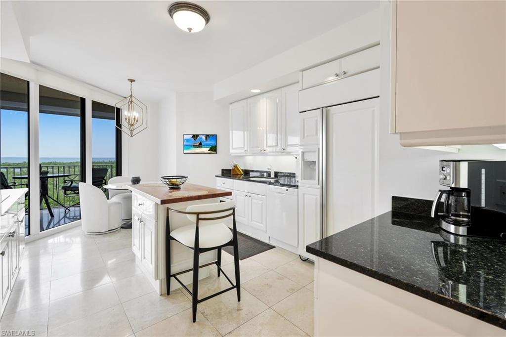 6597 Nicholas Boulevard, Unit 705 Naples, FL 34108 - Photo 12 of 34 a kitchen with a sink refrigerator and cabinets