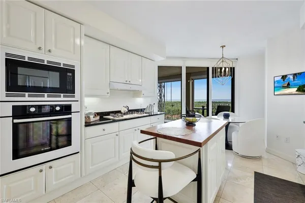 a kitchen with stainless steel appliances kitchen island granite countertop a stove a sink and a microwave