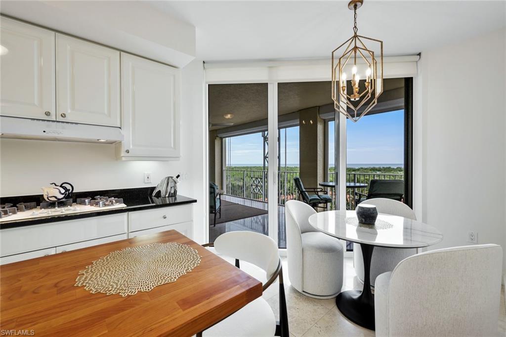 6597 Nicholas Boulevard, Unit 705 Naples, FL 34108 - Photo 14 of 34 a kitchen with stainless steel appliances granite countertop a stove and white cabinets
