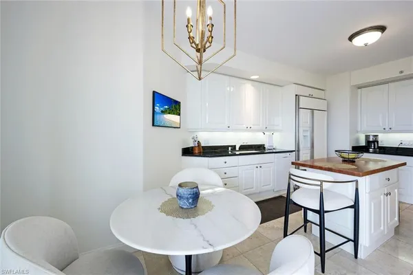 a kitchen with stainless steel appliances granite countertop a sink a stove a dining table and chairs