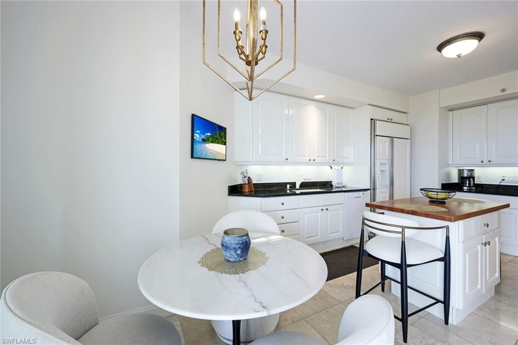 6597 Nicholas Boulevard, Unit 705 Naples, FL 34108 - Photo 15 of 34 a kitchen with stainless steel appliances granite countertop a sink a stove a dining table and chairs