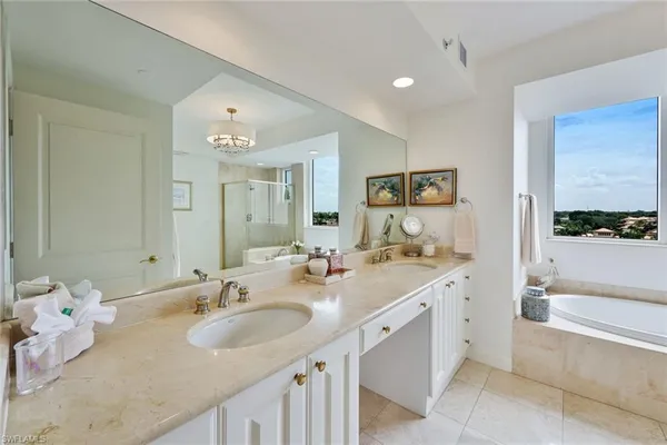 a bathroom with a double vanity sink mirror and bathtub