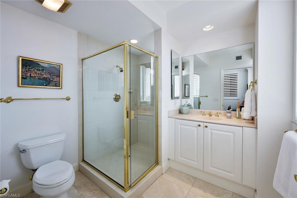 6597 Nicholas Boulevard, Unit 705 Naples, FL 34108 - Photo 22 of 34 a bathroom with a granite countertop sink toilet and shower
