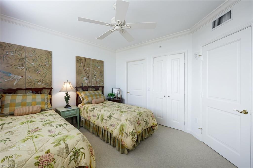 6597 Nicholas Boulevard, Unit 705 Naples, FL 34108 - Photo 23 of 34 a spacious bedroom with two beds and painting on the wall
