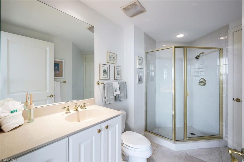 6597 Nicholas Boulevard, Unit 705 Naples, FL 34108 - Photo 24 of 34 a bathroom with a sink toilet a mirror and shower