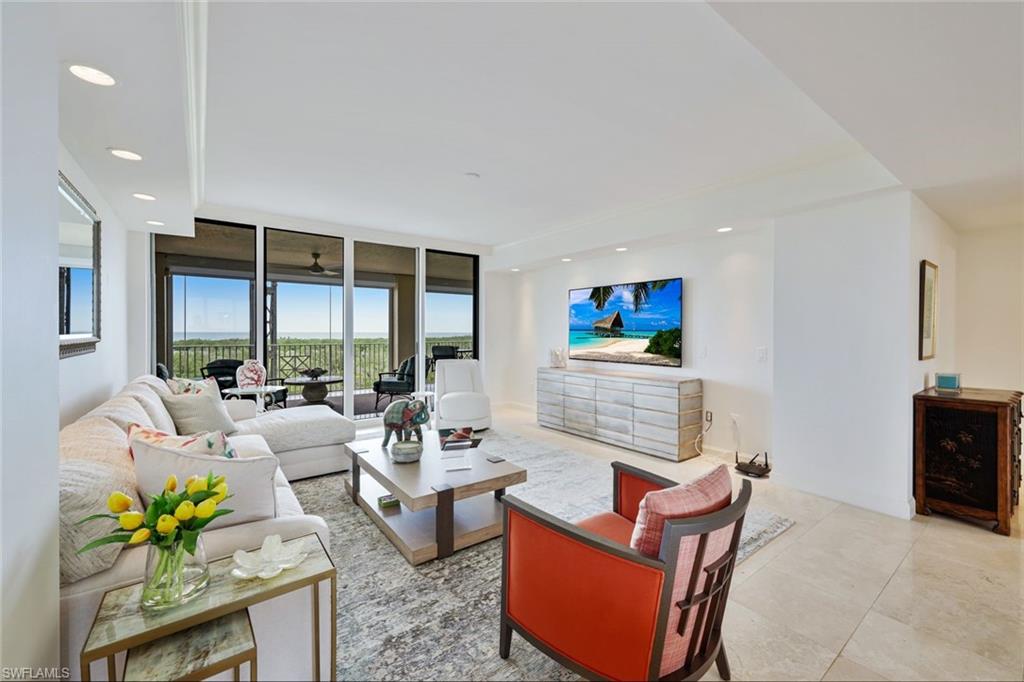 6597 Nicholas Boulevard, Unit 705 Naples, FL 34108 - Photo 9 of 34 a living room with furniture a floor to ceiling window and a flat screen tv
