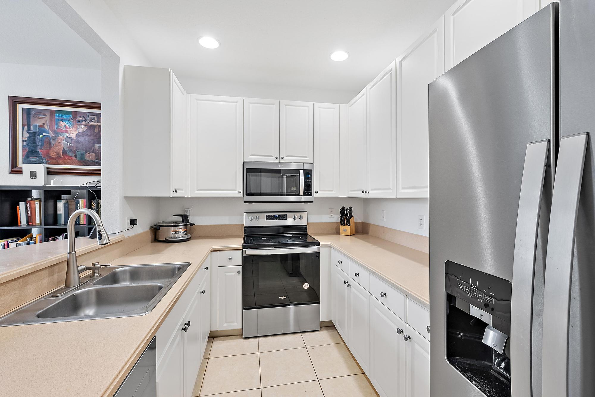4237 East Main Street Jupiter, FL 33458 - Photo 8 of 21 a kitchen with white cabinets sink and stainless steel appliances