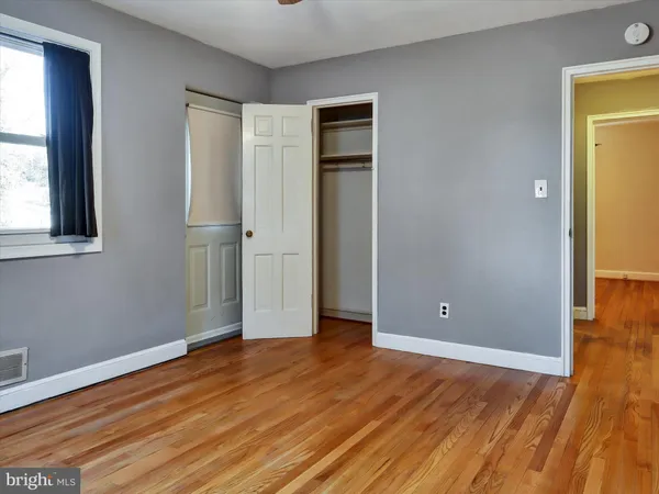 a view of a hallway with wooden floor and closet area