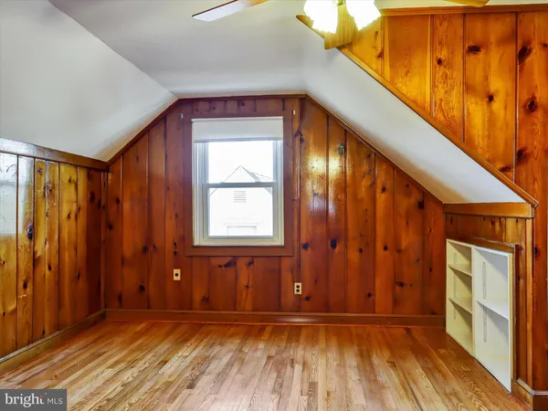 an empty room with wooden floor and chandelier