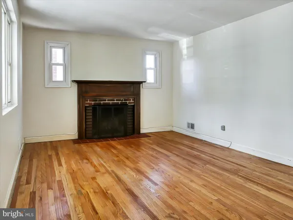 a view of empty room with wooden floor and fireplace