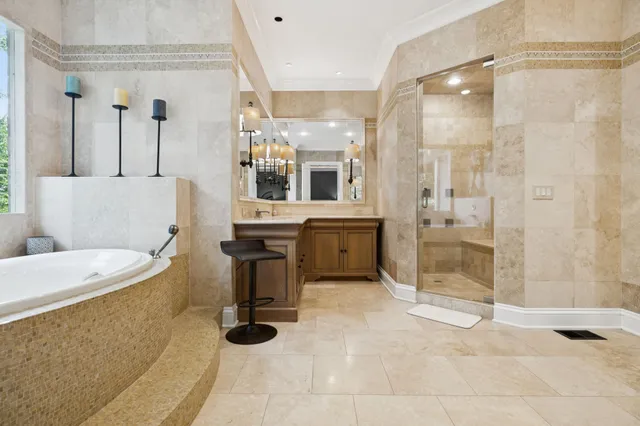 a spacious bathroom with a granite countertop sink a mirror and a bathtub