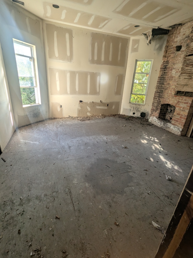 7732 South Normal Avenue Chicago, IL 60620 - Photo 14 of 29 a view of an empty room with a fireplace and a window