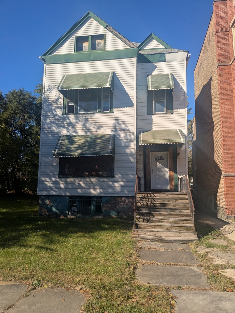 7732 South Normal Avenue Chicago, IL 60620 - Photo 2 of 29 a front view of a house with a yard