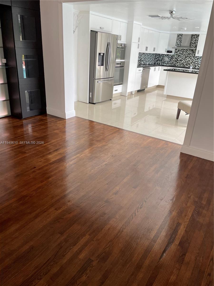 5321 Southwest 89th Court Miami, FL 33165 - Photo 4 of 4 an empty room with wooden floor and a kitchen