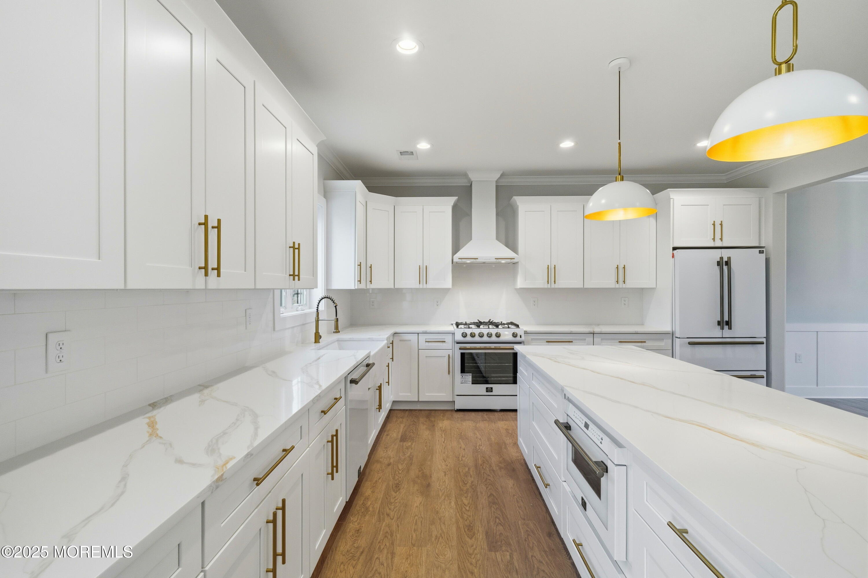 421 Roland Avenue Bayville, NJ 08721 - Photo 14 of 45 a large white kitchen with stainless steel appliances granite countertop a stove a sink a refrigerator and white cabinets with wooden floor