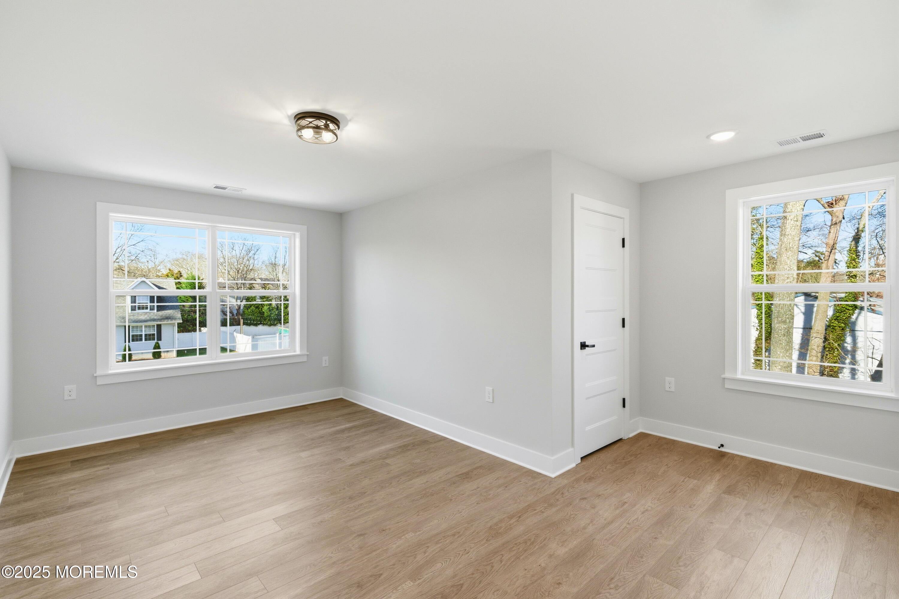 421 Roland Avenue Bayville, NJ 08721 - Photo 24 of 45 an empty room with wooden floor and windows