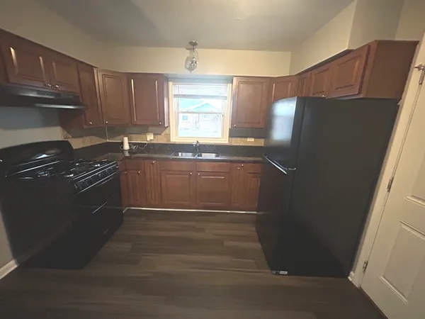 a kitchen with granite countertop a refrigerator and a sink