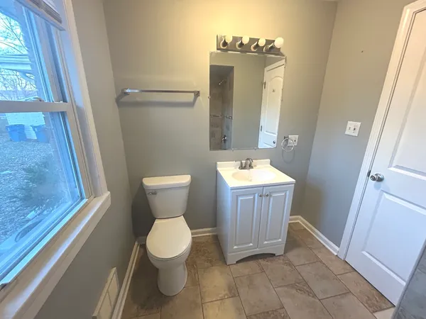 a bathroom with a toilet a sink and a mirror