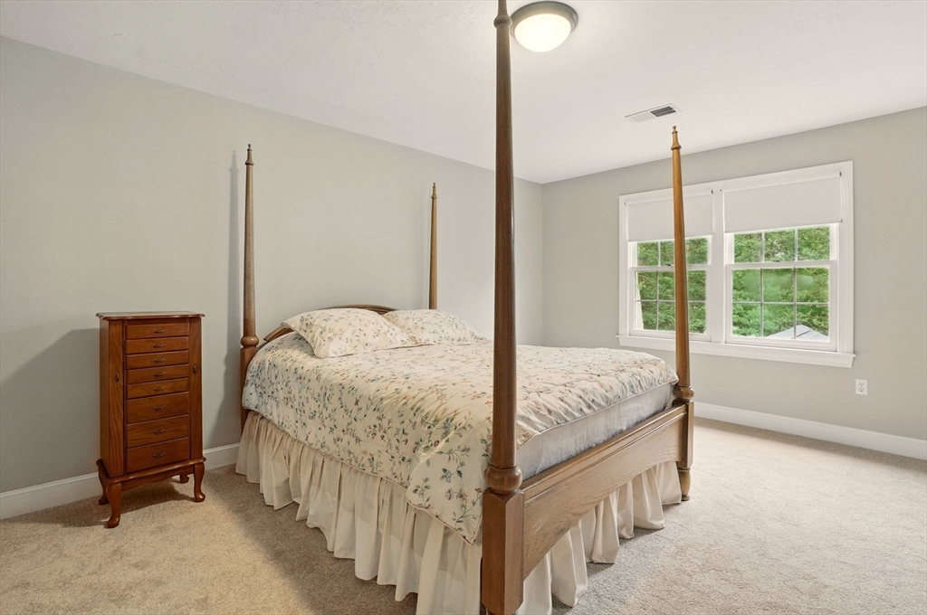 36 Buehler Road Bedford, MA 01730 - Photo 19 of 40 a bedroom with a bed window and a chandelier