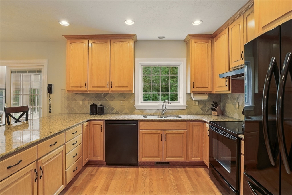 36 Buehler Road Bedford, MA 01730 - Photo 6 of 40 a kitchen with stainless steel appliances granite countertop refrigerator a sink dishwasher a stove top oven a refrigerator with wooden cabinets and floor