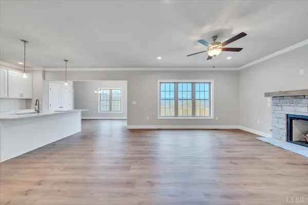 a view of an empty room with a kitchen and wooden floor