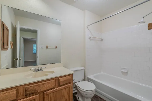a bathroom with a granite countertop sink a toilet and shower