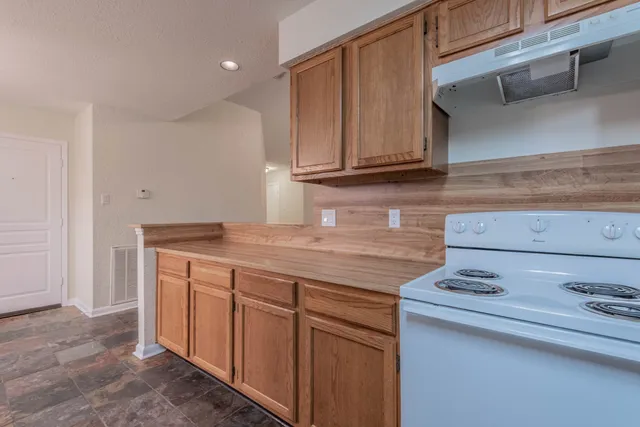 a kitchen with granite countertop wood cabinets and a sink