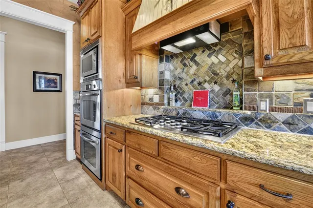 a kitchen with stainless steel appliances granite countertop a stove and a cabinets